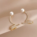 Nahaufnahme eleganter goldener Schlangen-Ohrring mit Perle und Kristalleinlagen - Gold