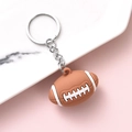 Brauner American Football Schlüsselanhänger mit weißen Details und silbernem Ring - Rugbyball