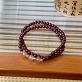 Gros plan d'un bracelet double rang en grenat et quartz fraise sur bois poli - Style à double boucle / Rouge Vin/Rose