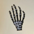 Gothic Skeletthand Haarspange in Schwarz mit weißen Knochendetails auf Metallhintergrund - Schwarz