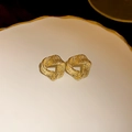 Golden irregular geometric metal earrings with a textured lava finish on ceramic tray - Geometric Hollow Style (14#)