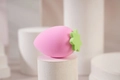 Strawberry shaped pink makeup sponge with green leaf detail on a white pedestal - Light Pink Strawberry