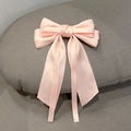 Detail of light pink satin bow hair clip with elegant long ribbon streamers - Pink