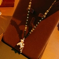 Detail of tiger eye beaded necklace with gold plated bear pendant on jewelry stand - Bear Pendant Contrast Beaded Style / Gold/Brown/Green