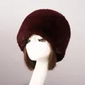 Close-up of deep red faux fur Russian style hat with thick fluffy texture on a mannequin - Purplish Red Faux Rex Rabbit Fox