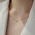 Minimalist gold titanium necklace featuring water drop gemstone and round pendants on model - White Zircon Teardrop / Gold