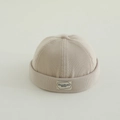 Detalle del tejido de punto acanalado beige y del parche decorativo en el gorro infantil - Blanco Roto