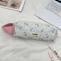 Close-up of floral pencil case with pink fabric handle on a study desk scene - Blue Twill