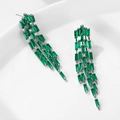 Elegante smaragdgrüne Quastenohrringe mit Silberbasis in einer schlichten Umgebung - Silber Grüner Stein