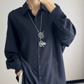 Detalle de collar minimalista con colgante de ojo metálico sobre una camisa azul marino - Collar-Forma de Gafas / Plateado
