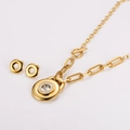 Vue macro du collier trombone plaqué or et des boucles d'oreilles assorties en zircon - Doré