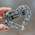 Gros plan détail d'une pince à cheveux cœur en strass scintillants, barrette cristal. - Blanc Coloré