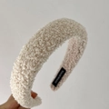 Primer plano de diadema blanca crema de lana de cordero con etiqueta tejida Hand Made - Albaricoque