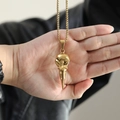 Detailed view of polished golden crow skull pendant on a necklace held in hand - Gold Color (No Chain)
