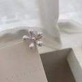 Dettaglio di un fermaglio per capelli a fiore con perle e base dorata su cartoncino - 1 Pezzo / Bianco perla