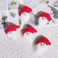 Set of five handmade red felt Santa Claus ornaments on a cozy white knit blanket - Santa Head / Red
