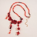 Detail of red acrylic flower necklace with black faceted beads and adjustable chain - Flower Tassel Style / Red