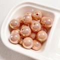 Macro detail of round champagne pearl beads with iridescent coating for DIY jewelry - Deep Orange Pink
