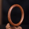 Polierter Sandelholz-Armreif mit natürlicher Maserung auf einem Holzsockel gezeigt - 62mm / Rundstab-8mm / Afrikanisches Rosenholz