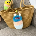 Detail van een kleurrijke pluche monster sleutelhanger met zonnebril aan bruine tas - Donkerblauwe Kop