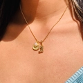 Collar de bolas dorado con colgantes de concha perlada y bota vaquera en una modelo femenina - Concha de perla
