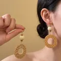 Detail view of handmade woven rattan drop earrings with wooden beads on model - 11# Steel Earring Post - Rattan Circle with Wood Bead