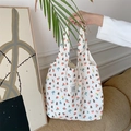 Borsa tote in tela a fiori con orsetti portata da una modella in un interno morbido - Orso di Fiori