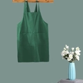 Linen cotton apron in green with a large front pocket hanging on a wooden hanger - Kids Green