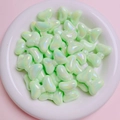 Detailed view of pale green iridescent bow-shaped beads for DIY jewelry making - Light Green