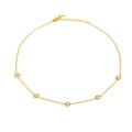 Dettaglio di una collana in acciaio al titanio dorato con cinque eleganti perle bianche - Collana di perle