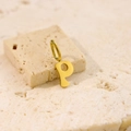 Minimalist gold stainless steel letter P pendant necklace on a beige stone surface - Letter-P / Gold