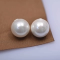 Glossy white round shell pearl beads for DIY jewelry making on brown silk background - 4mm Half Hole / Iridescent White