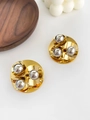 Detailed macro view of two-tone gold and silver geometric ball earrings on a wood tray - Mixed Color Beads