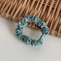 Elegant dusty blue satin scrunchie with a silk-like texture for stylish hairstyles - Cyan