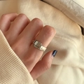 Minimalist silver multi-layer wavy ring with buckle design on a knit fabric background - Adjustable Open / Width