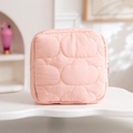 Detail of pink quilted storage bag with cloud stitching on a white wavy surface - Pink