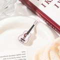 Detalle macro de la pinza para el pelo de guitarra rosa con cuerdas y texturas finas - Rosa