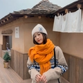 Soft orange cashmere-like scarf with fringe tassels shown on a model in a cozy winter setting - Orange & Yellow