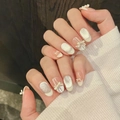 Dettaglio di unghie artigianali con glitter argento, fiocchi 3D e design French chic - XS / 388-Ovale Corto