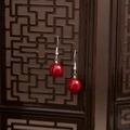 Detail of red beaded drop earrings with silver hooks against a vintage wooden screen - Red Bead Classical Screen