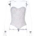 Dettaglio del corsetto in pizzo color crema con ricami floreali e scollatura a cuore - S / Bianco