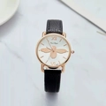 Detail view of white watch face with gold bee motif and rose gold stainless steel case - Black Strap White Dial