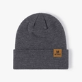 Dark grey knitted beanie with brown leather M patch and ribbed texture for winter warmth - One Size / Deep Heather Grey