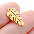 Golden monstera leaf stainless steel pendant charm shown held between fingers - DY744 Monstera Leaf / Gold
