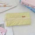 Detailed close-up of yellow quilted fabric pencil case with diamond pattern stitching - Bright yellow