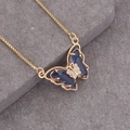Dettaglio di una collana in oro 18K con un pendente a farfalla in pietra preziosa blu - Blu Scuro