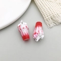 Detailed macro view of two red resin miniature ice cream pendants with white cream tops - 1pc Red Resin Sundae Ice Cream Cup