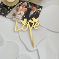 Close-up of golden LOVE acrylic cake topper with birds on a romantic wedding display - Birds and Heart - LOVE