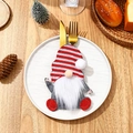 Christmas gnome cutlery holder with red striped hat holding golden silverware on a plate - Faceless Gnome Cutlery Set C