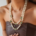 Detail view of double-layer pearl necklace with vintage gold emerald gemstone charms - Necklace-White